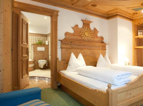 a bedroom with two beds with a wooden headboard at Hotel Gallia in Stelvio