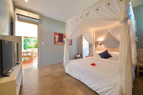 a bedroom with a white bed and a tv at Diniview Villa Resort in Boracay