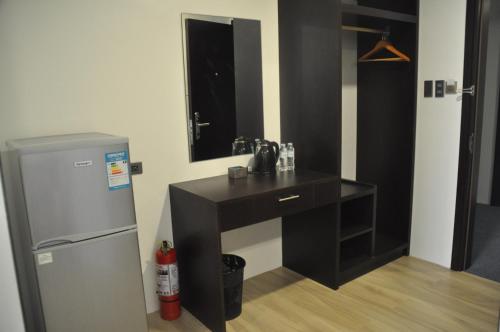 a bathroom with a sink and a mirror and a refrigerator at Mezzo Hotel in Cebu City