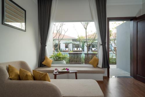 a living room with a couch and a large window at Sabara Angkor Resort & Spa in Siem Reap