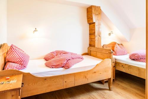 a room with two bunk beds with red and white pillows at Wohlfühlbauernhof Bambichlhof in Fuschl am See