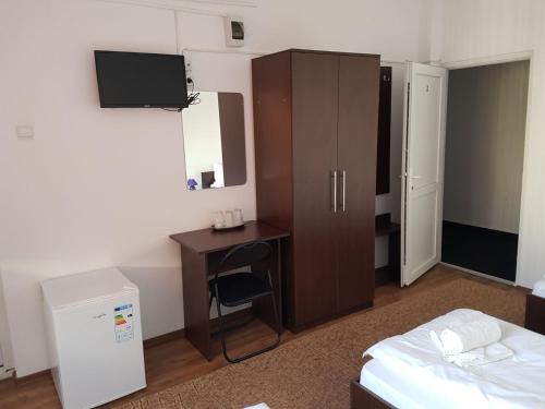ファガラシュにあるPiete Targuri Si Oboareのベッドルーム(デスク、ベッド1台付)、キャビネットが備わります。
