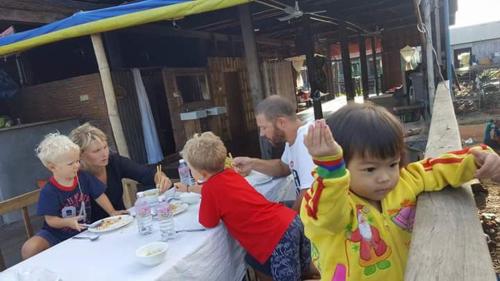 a group of children sitting at a table eating at ST 63 Home Stay & Tour Kampong Khleang in Kâmpóng Khleăng