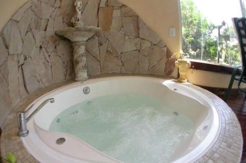 y baño con bañera y pared de piedra. en Hotel Gran Robette en Ostende