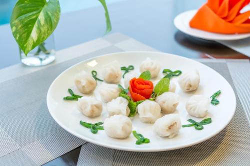 a white plate with dumplings on a table at Dana Marina Boutique Hotel in Da Nang