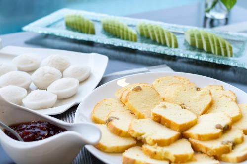 a plate of food with bread and a bowl of dips at Dana Marina Boutique Hotel in Da Nang