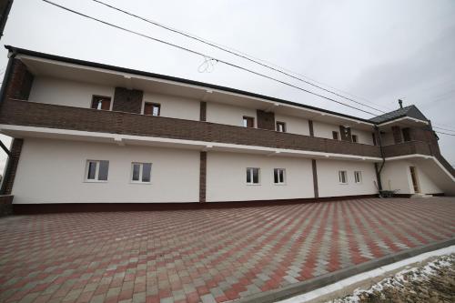 an external view of a building with a brick driveway at Fresh Accommodation in Rădăuţi