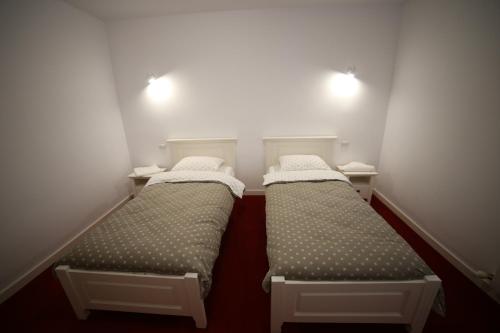 two beds in a small room with two lights at Fresh Accommodation in Rădăuţi