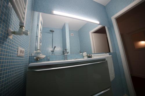 a blue bathroom with a sink and a mirror at Fresh Accommodation in Rădăuţi