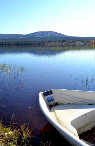 a white boat sitting on the shore of a lake at Talo Ylläs in Äkäslompolo