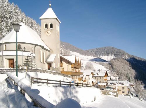 a church on a snow covered hill with a building at Hotel Gallia in Stelvio