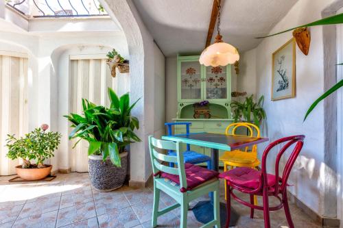 una colorata sala da pranzo con tavolo e sedie di Apartment Tempo Colorato a Mali Lošinj (Lussinpiccolo)