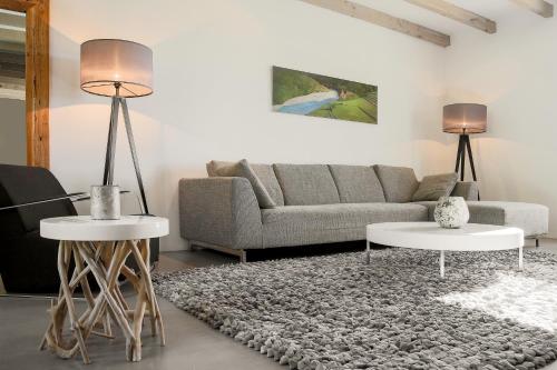 a living room with a couch and two tables at Château Les Merles et ses Villas in Mouleydier