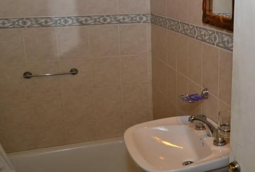 W łazience znajduje się umywalka, biała wanna i umywalka. w obiekcie Chawasi Cabañas w mieście Campo Quijano