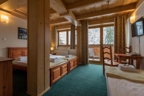 a room with two beds and a balcony at Ośrodek Wypoczynkowy Marymont przy Dolinie Kościeliskiej in Kościelisko