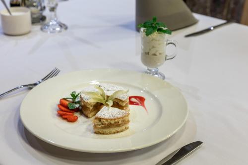 a white plate with a piece of food on a table at Ośrodek Wypoczynkowy Marymont przy Dolinie Kościeliskiej in Kościelisko
