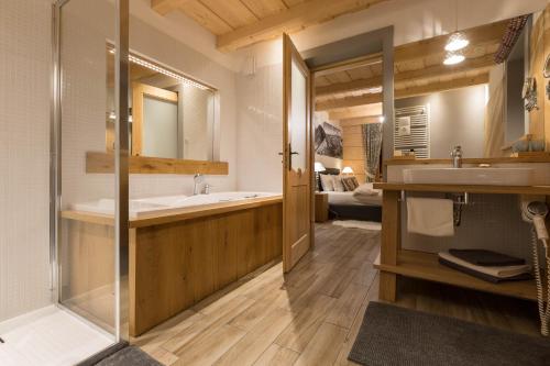 W łazience znajduje się wanna, umywalka i lustro. w obiekcie Aparthotel Bambi w Zakopanem