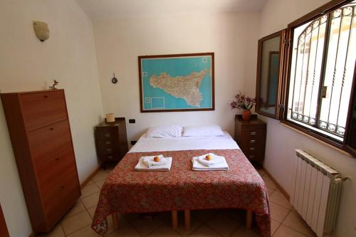 a bedroom with a bed and a table with two towels at Villa Giulia in Castellammare del Golfo
