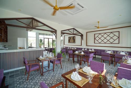 a dining room with tables and purple chairs at Sabara Angkor Resort & Spa in Siem Reap