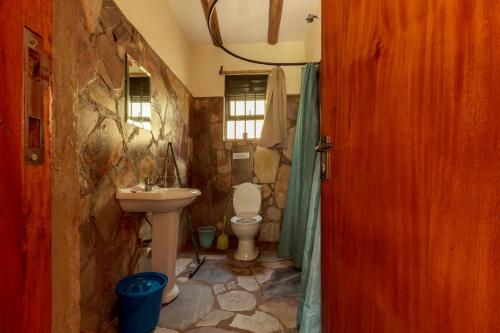 a stone bathroom with a sink and a toilet at Gorilla Valley Lodge in Bwindi Impenetrable Park