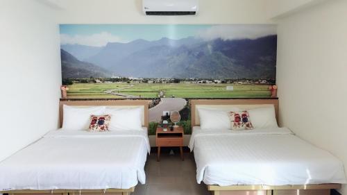 台東市にあるコージー ライフの山を背景にした部屋にベッドが2つある
