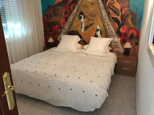 ラ・カラ・デ・ミハスにあるCasa playa el Torreonのベッドルーム1室(壁に絵画が描かれた大型ベッド1台付)
