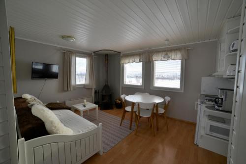 a bedroom with a bed and a table and a kitchen at Guesthouse Haltinmaa in Kilpisjärvi