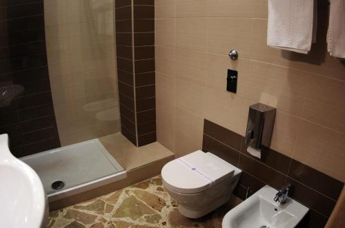 e bagno con servizi igienici, lavandino e doccia. di diVino Hotel a Rilievo