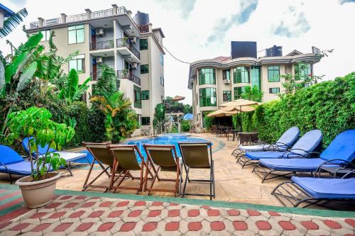 a patio with chairs and a table and a pool at Green Mountain Hotel in Arusha