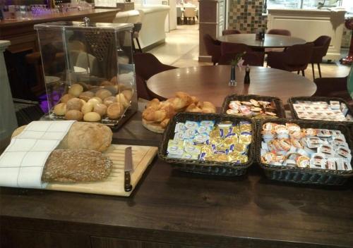 a table with many different types of bread and pastries at Brasserie-Hotel Antje van de Statie in Weert