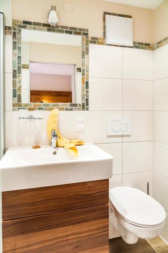 a bathroom with a white sink and a toilet at Wohlfühlbauernhof Bambichlhof in Fuschl am See