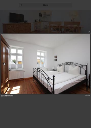 a bedroom with a large bed with white sheets and a window at Gästehaus Schimmel´s in Wustrow