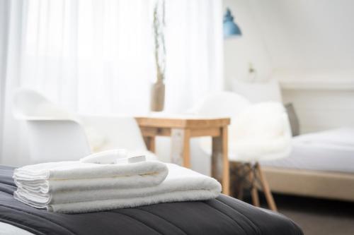 a stack of towels sitting on top of a bed at B&B Boutique Hotel De Waal in De Waal