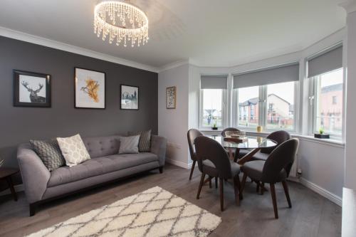 a living room with a couch and a table and chairs at Dunfermline - Luxury Two Bedroom Apartment - TP in Dunfermline