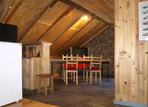 une salle à manger avec une table et des chaises en bois dans l'établissement Au Bout De La Route, à Prads-Haute-Bléone