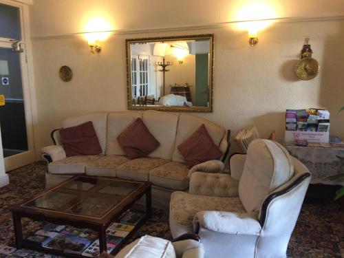 a living room with a couch and a mirror at The Whiteley in Scarborough