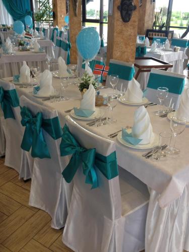 a table with white tables with hats and bows at Ostrov River Club in Novosëlovka