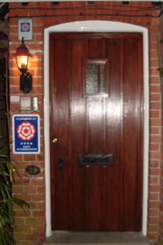 a wooden door in a brick building with a sign on it at Tower House 1066 in Hastings