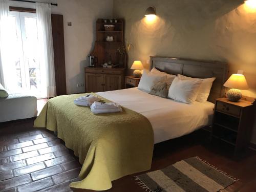 a bedroom with a bed with two towels on it at Herdade Do Freixial - Turismo Rural in Vila Nova de Milfontes