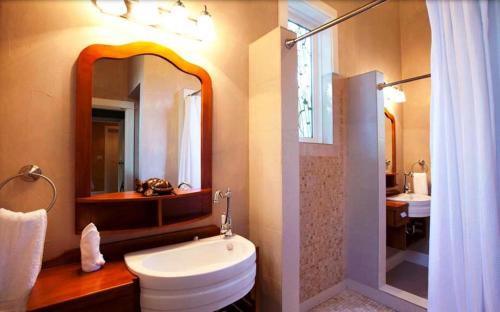 a bathroom with a toilet and a sink and a mirror at Hermosa Cove Villa Resort & Suites in Ocho Rios