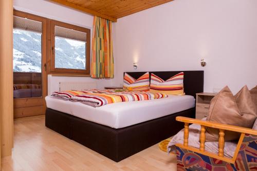 a bedroom with a large bed with colorful pillows at Ferienwohnung Eberharter Theresia in Ramsau im Zillertal