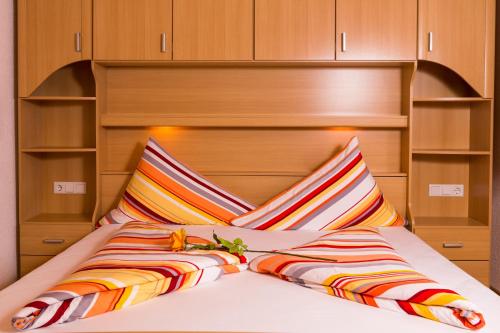 a bed with a headboard and two pillows at Ferienwohnung Eberharter Theresia in Ramsau im Zillertal