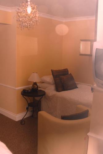 a bedroom with a bed and a table with a lamp at Tower House 1066 in Hastings