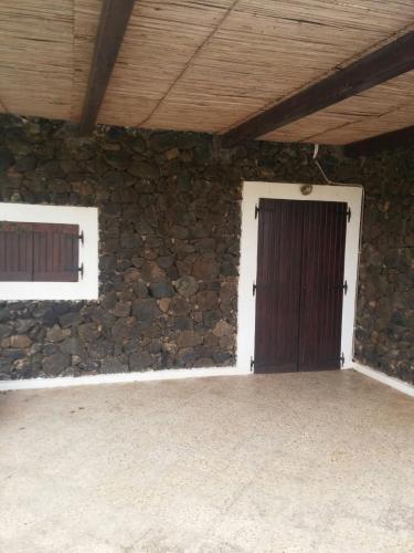 パンテレリアにあるla casa di Bukkuramの石壁と木製のドアが特徴の客室