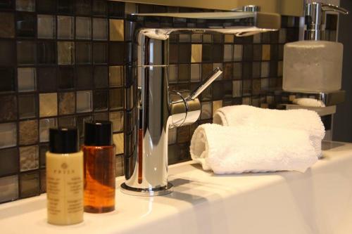 a bathroom sink with towels and a faucet at Strand-Hotel Seenelke in Wilhelmshaven