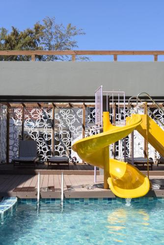a yellow slide in the water at a swimming pool at Maldives Beach Resort in Chao Lao Beach