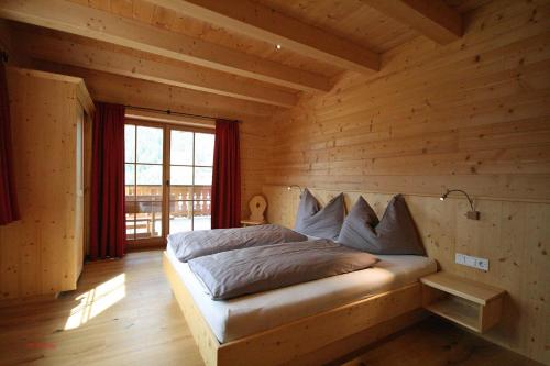 a bedroom with a bed in a log cabin at Almliesl MUEH-512 in Bramberg am Wildkogel