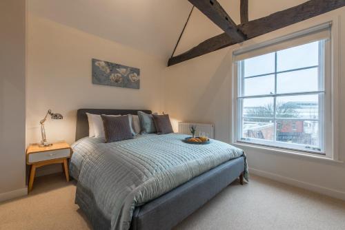 ウィンザーにあるCentral Windsor Apartment Facing the Castleのベッドと大きな窓のある寝室