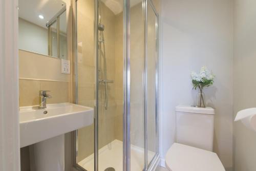 y baño con ducha, lavabo y aseo. en Central Windsor Apartment Facing the Castle, en Windsor