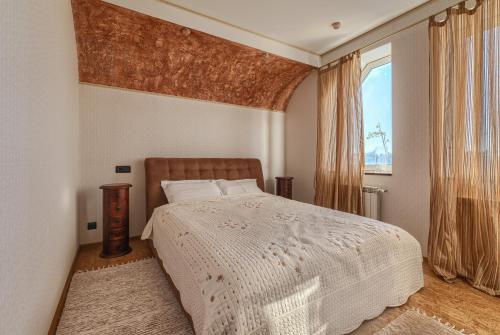 a bedroom with a white bed and a window at Villa de Jardin in Svyatopetrivske